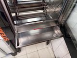 many stainless steel trays that are lined up on the floor