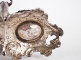 a close up of a silver object with a clock in it