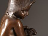 bronze statue of a boy with a hat holding a rabbit