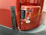 a close up of a red car with a ruler on the back of it