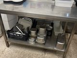 a stainless steel table with pots and pans on it