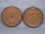 two brown plates sitting on a table with a white background