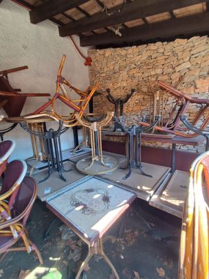 Dans le patio : 16 tables carrées en bois mélaminé siglées "…