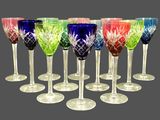 six verres à vin multicolores sont alignés en rangée