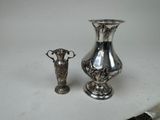 two silver vases sitting next to each other on a table