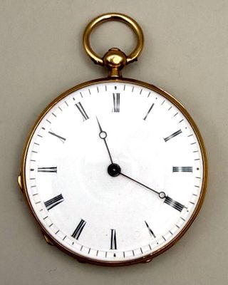 une montre de poche en or avec des chiffres romains sur le cadran