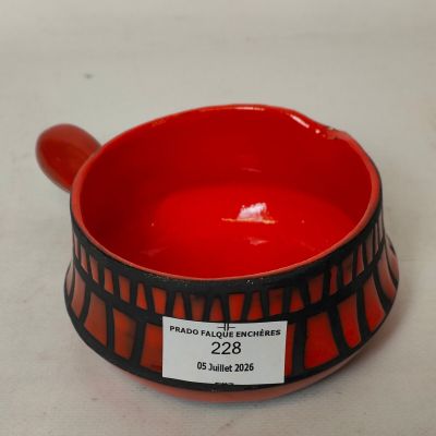 un bol rouge orné d'un motif noir et blanc