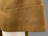 a close up of a mannequin head wearing a brown coat