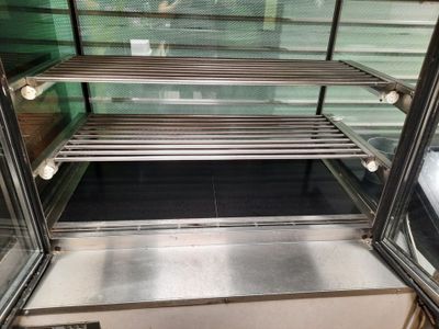 une vitrine en verre contenant beaucoup de nourriture