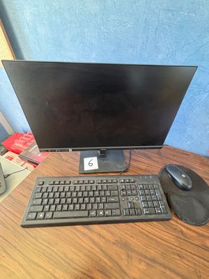 un écran d'ordinateur et un clavier posés sur un bureau