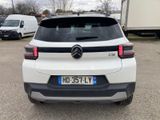 the rear of a white car parked in a parking lot