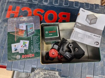 a box of tools on a table that includes a camera, a cell phone, and a box of cards