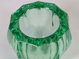 a green glass vase that is sitting on a table