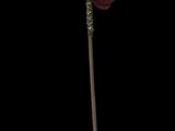 a red flower that is on a stick in the dark