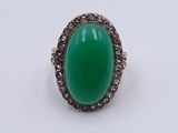 an image of a green jade and diamond ring on a white surface