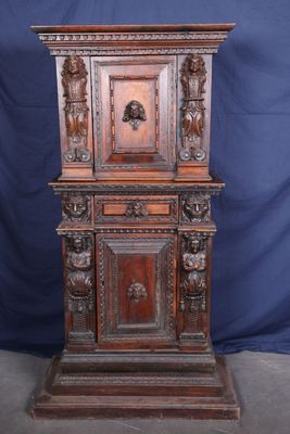 une vieille armoire en bois ornée de sculptures sur la façade