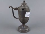 an antique silver plated teapot with a lid on a pedestal