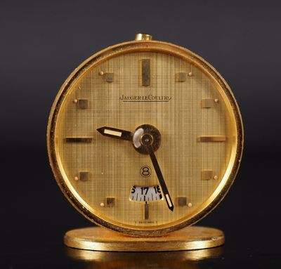 a gold clock that is sitting on a table