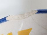 a white bowl with a blue and yellow fish design on it