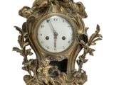 une horloge en or posée sur une surface blanche