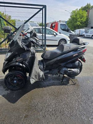 a scooter parked in a parking lot next to a fence