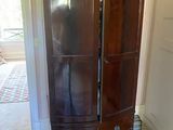 a tall wooden cabinet with a mirror on top of it