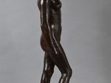a bronze statue of a man standing on a wooden base