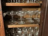 a wooden cabinet with many glasses on top of it