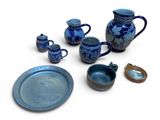 several pieces of blue pottery sitting on top of a white surface