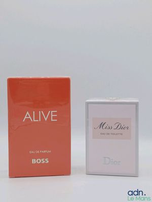 two boxes of perfume sitting next to each other on a white surface