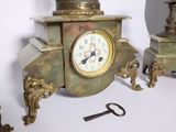 a small clock sitting on a table next to a key