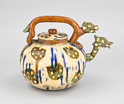 une théière bleue et blanche avec une anse en bois