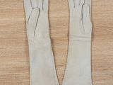two pairs of white leather gloves on a wooden surface
