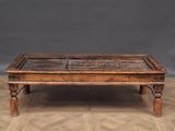 an old wooden coffee table with a glass top on a parquet floor