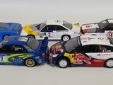several toy cars are lined up in a row on a white surface