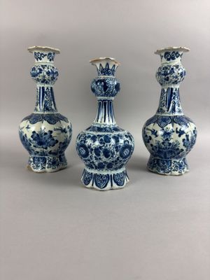 trois vases bleus et blancs posés les uns à côté des autres sur une table