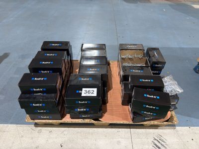 Plusieurs cartons sont empilés sur une palette dans la rue.