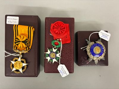 Trois boîtes contenant des médailles et des rubans sont exposées sur une table