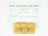 a gold bar sitting on top of a piece of paper