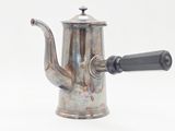 une théière en argent avec une anse noire sur fond blanc