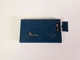 the back of a blue plastic device with a metal latch on it