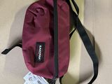 a red bag with a tag on it sitting on the floor