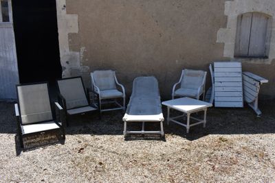 four chairs and a table in front of a building