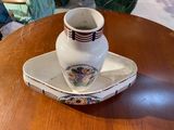 a white vase sitting on top of a tray on a table