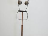 a metal mannequin on a wooden stand in a white room