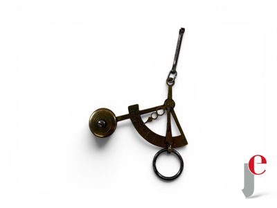 a clock that is on a white surface with a keychain
