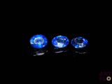 three blue sapphires on a black background