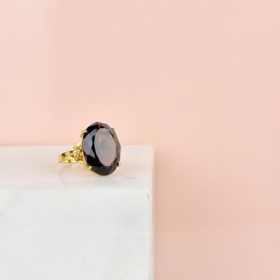 a black stone ring sitting on top of a white marble block