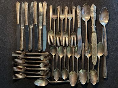 un grand nombre de cuillères et de fourchettes disposées sur une table