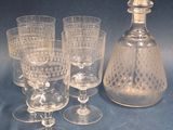 quatre verres à vin et une carafe posés sur une table